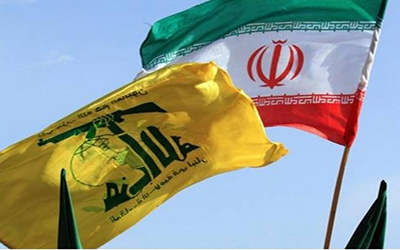 راية «حزب الله» في ظل العلم الإيراني (موقع بلومبرغ)