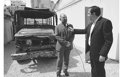 لقمان سليم وخلفه «بوسطة عين الرمانة»